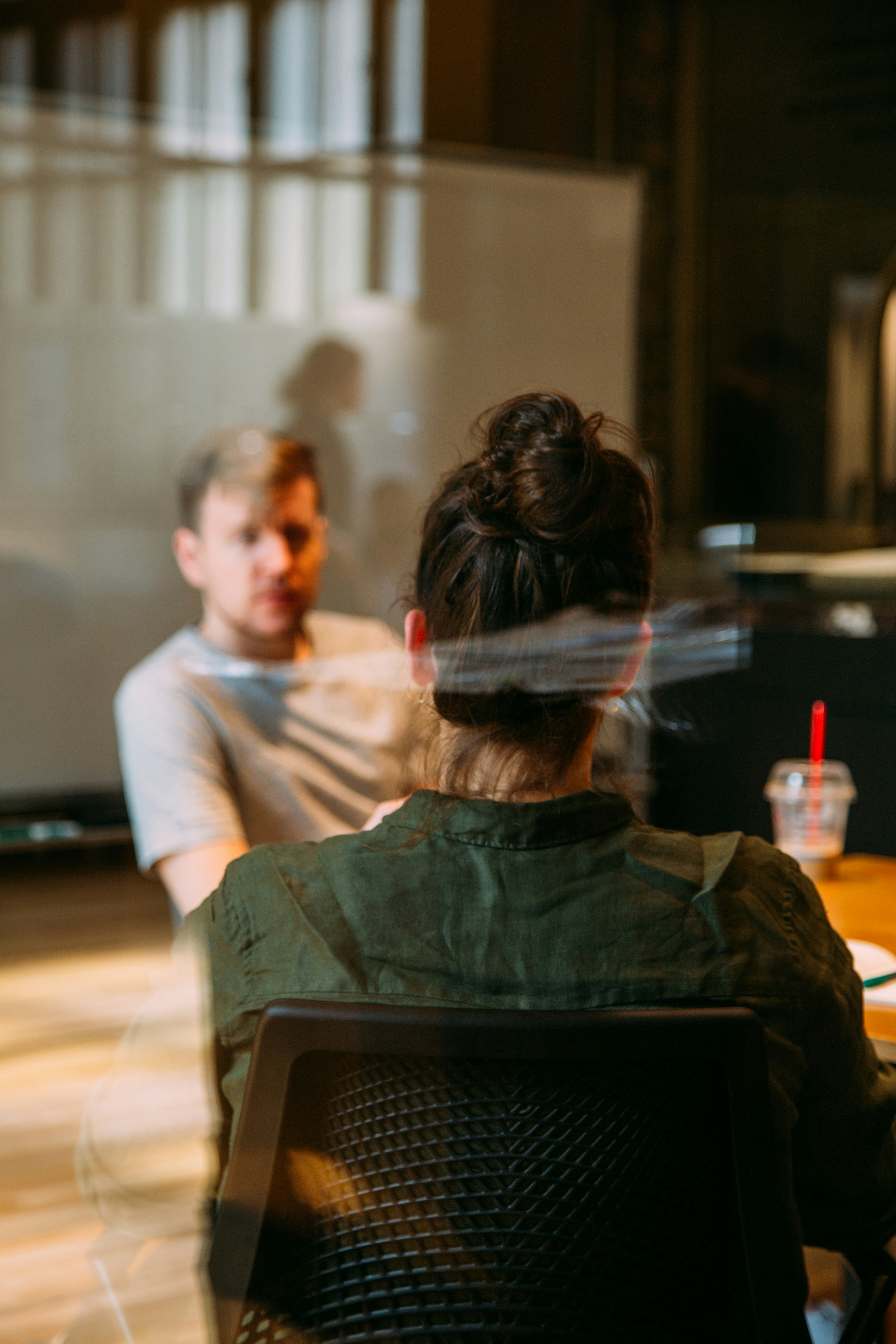 Image of people in an office seen through the glass partition